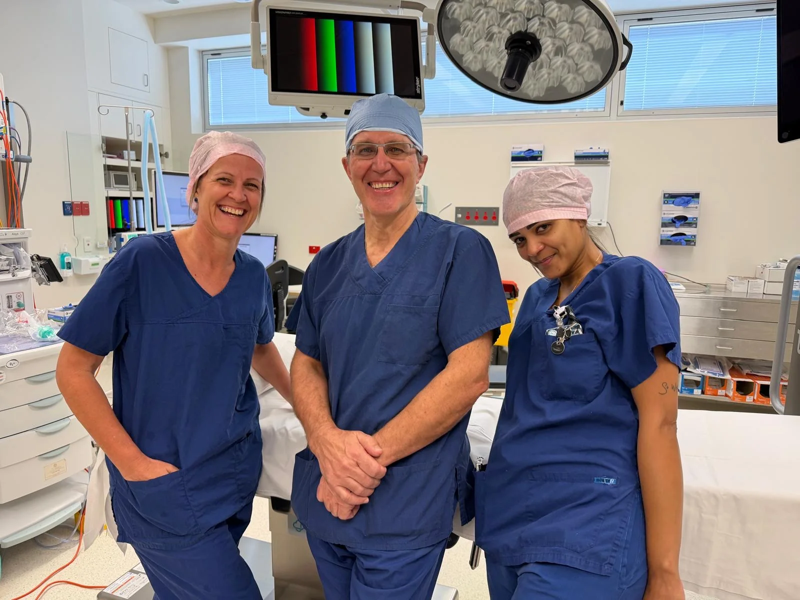 Dr Mikhail Mastakov and two members of the theatre team in surgical scrubs